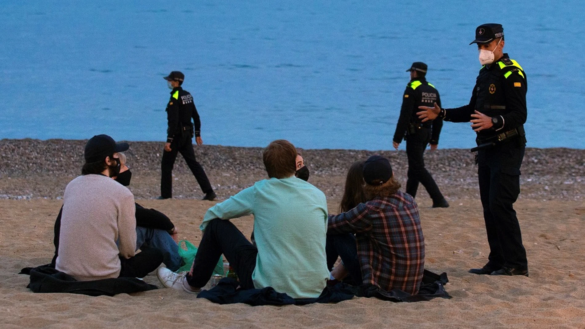 Un grupo de personas sentado en una playa de Barcelona