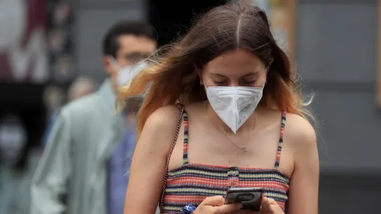 Una joven con mascarilla camina por Madrid Una joven con mascarilla camina por Madrid
