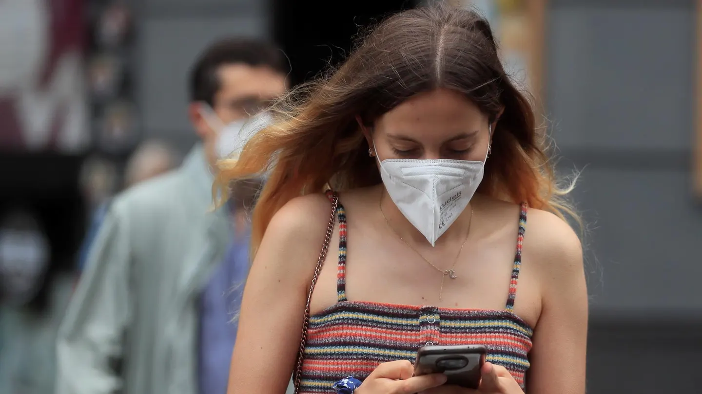 Una joven con mascarilla camina por Madrid Una joven con mascarilla camina por Madrid