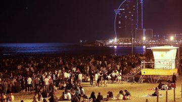 Cientos de personas celebran en la playa de la Barceloneta la noche de San Juan