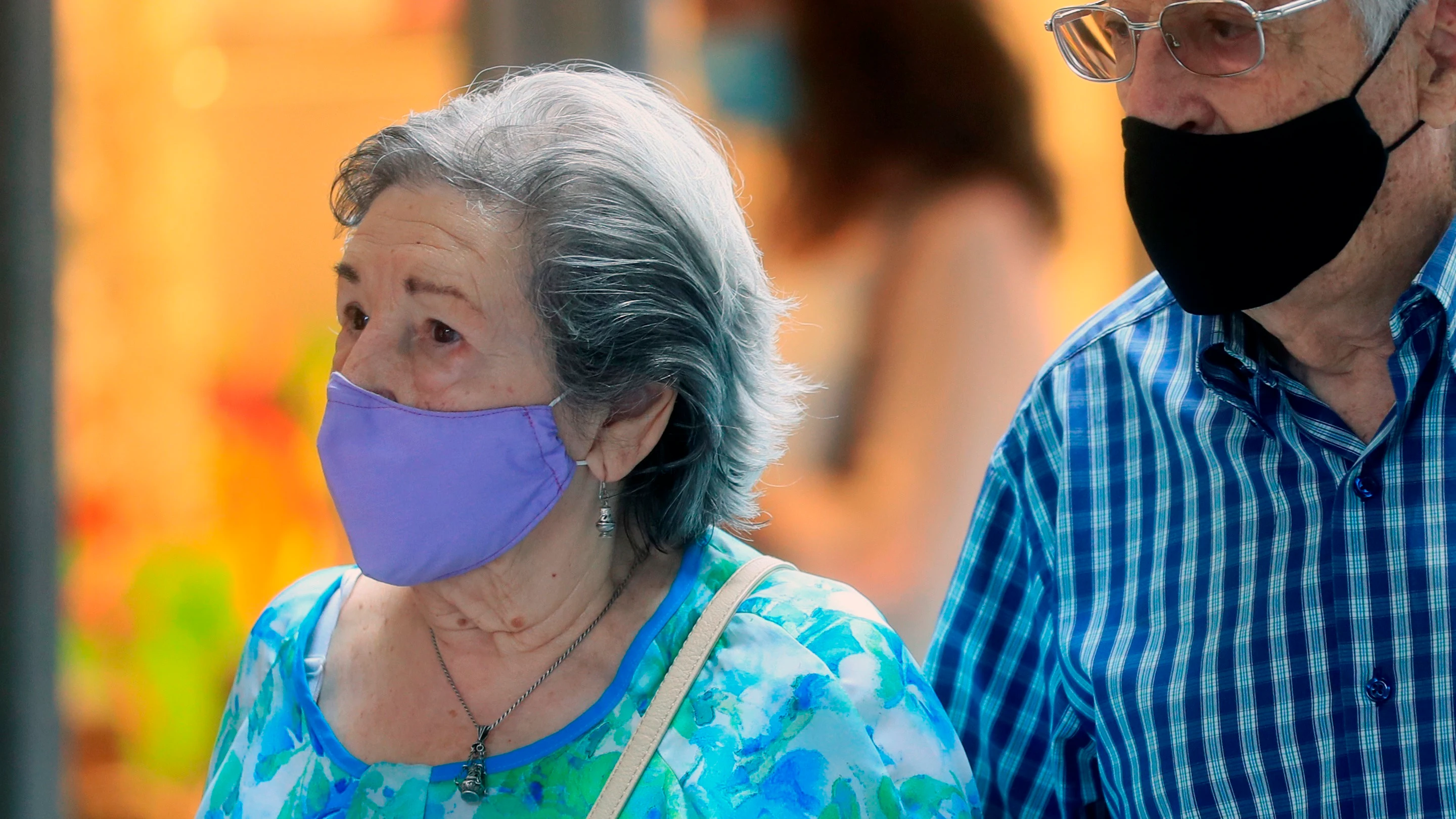 Varias personas con mascarilla caminan por una calle de Madrid