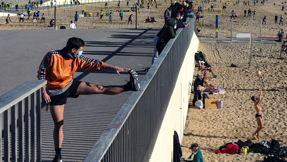 Varias personas practican deporte en la playa