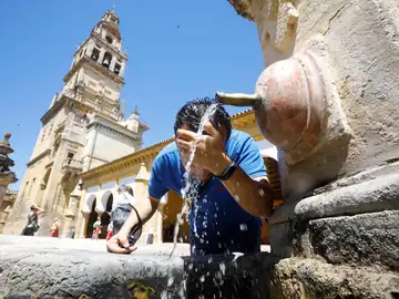 Un joven se refresca en una fuente céntrica de Córdoba debido a las altas temperaturas registradas. 
