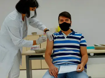 Una enfermera administra la vacuna a un empleado de El Corte Inglés en el centro comercial de Arapiles, en Madrid