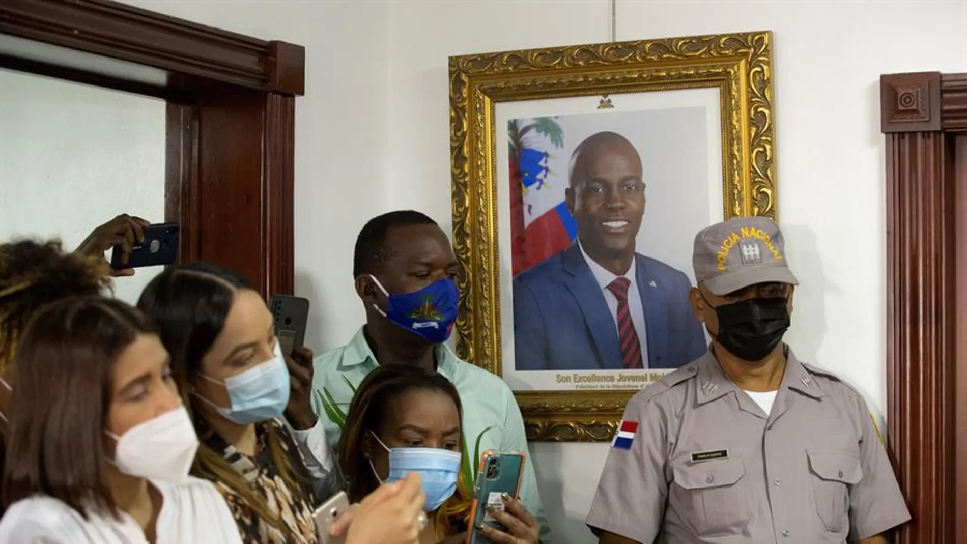 Periodistas junto a una fotografía del expresidente Jovenel Moise