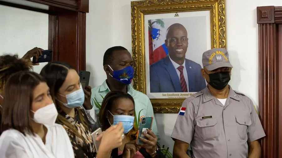 Periodistas junto a una fotografía del expresidente Jovenel Moise