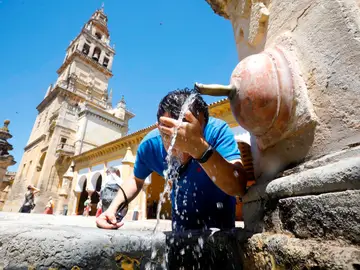 Un hombre se refresca en una fuente céntrica de Córdoba debido a las altas temperaturas registradas.