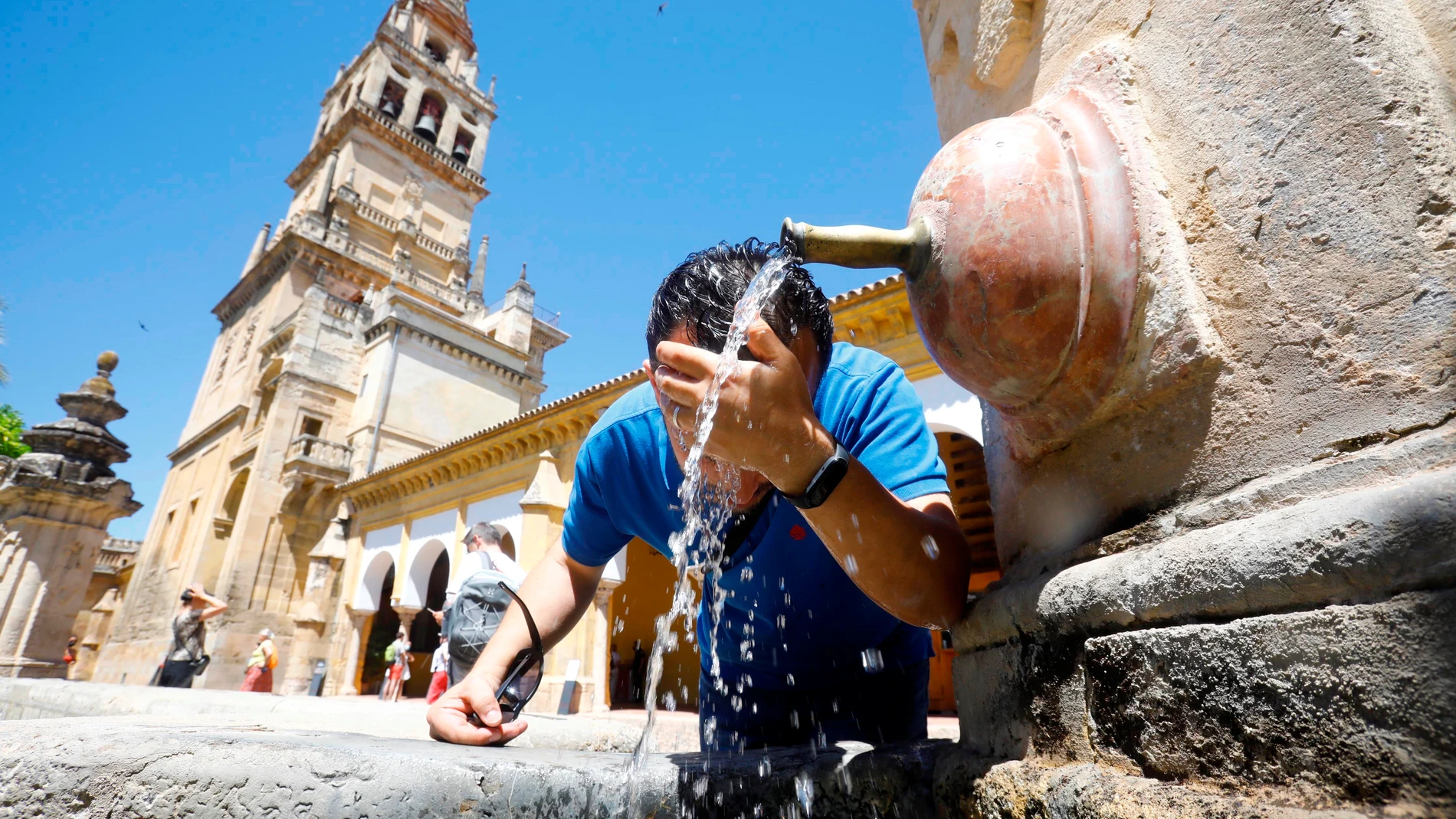 Un hombre se refresca en una fuente céntrica de Córdoba debido a las altas temperaturas registradas.
