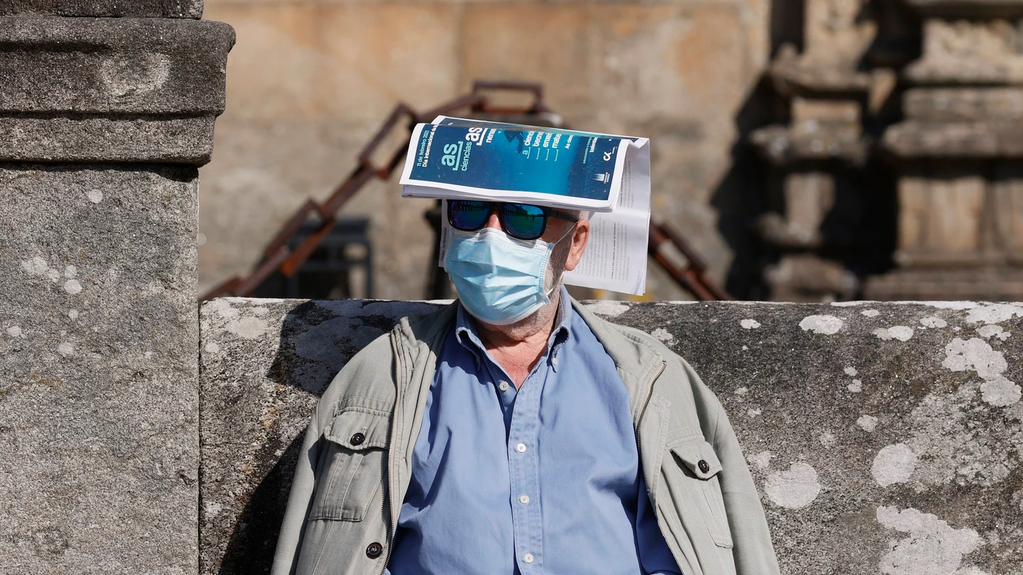 Un hombre se protege del sol con una revista sobre la cabeza en la plaza del Orbadoiro en Santiago de Compostela. Un hombre se protege del sol con una revista sobre la cabeza en la plaza del Orbadoiro en Santiago de Compostela.