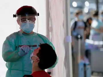 Un efectivo de Cruz Roja realiza una prueba PCR a un joven en Valladolid