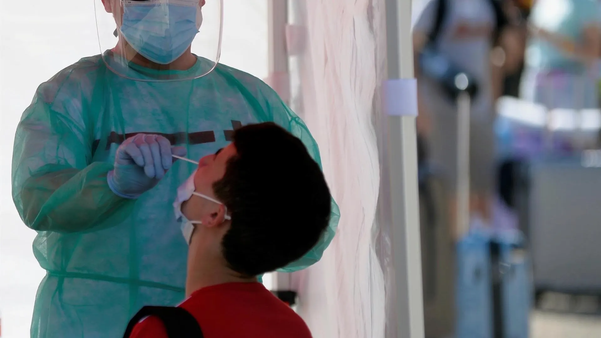 Un efectivo de Cruz Roja realiza una prueba PCR a un joven en Valladolid