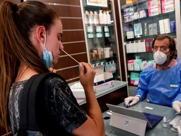 Un farmacéutico explica a una joven cómo realizar un autotest de antígenos en Barcelona Un farmacéutico explica a una joven cómo realizar un autotest de antígenos en Barcelona
