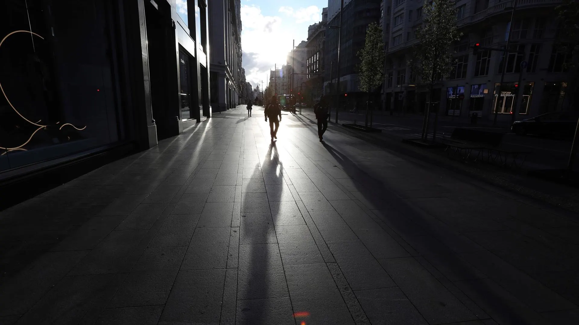 Varias personas transitan por la Gran Vía madrileña, en la primera jornada laboral bajo el estado de alarma decretado por el Gobierno (Archivo)