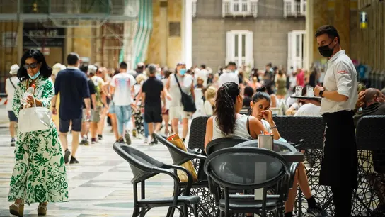 Un camarero atiende a los clientes en la terraza de un restaurante en Nápoles, Italia. Un camarero atiende a los clientes en la terraza de un restaurante en Nápoles, Italia.