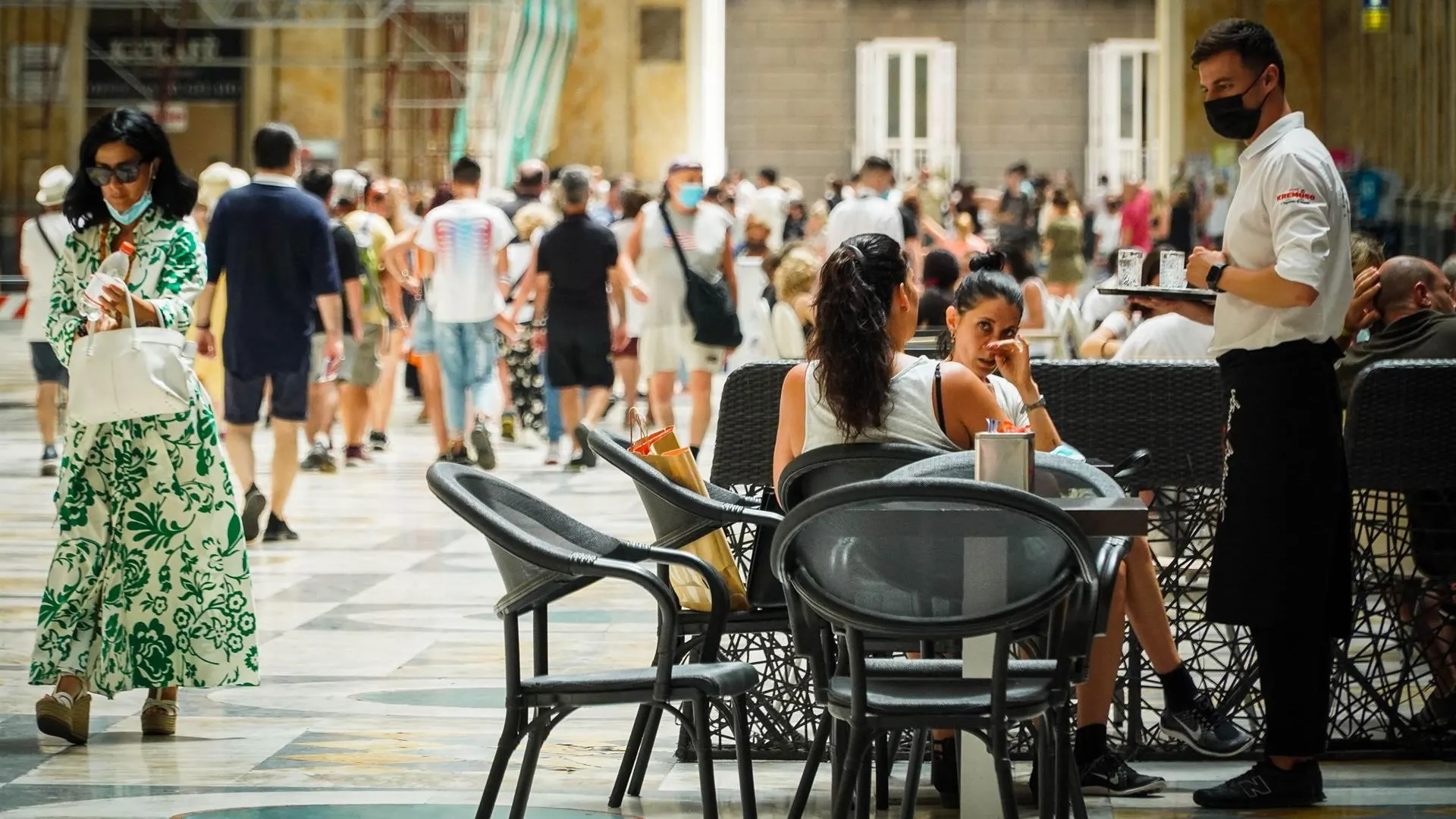 Un camarero atiende a los clientes en la terraza de un restaurante en Nápoles, Italia.