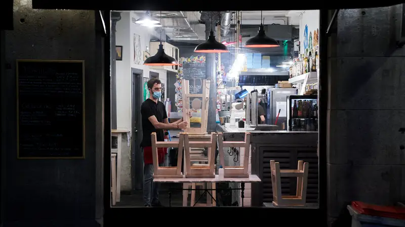 Un trabajador recoge el interior de una cafetería de Madrid