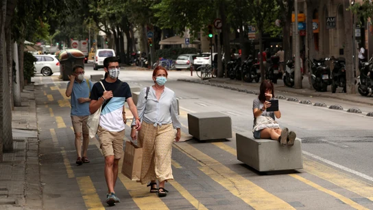Varias personas circulan por las calles de Barcelona Varias personas circulan por las calles de Barcelona
