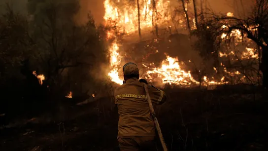 Un bombero combate las llamas durante un incendio en el pueblo de Pefki, Grecia Un bombero combate las llamas durante un incendio en el pueblo de Pefki, Grecia