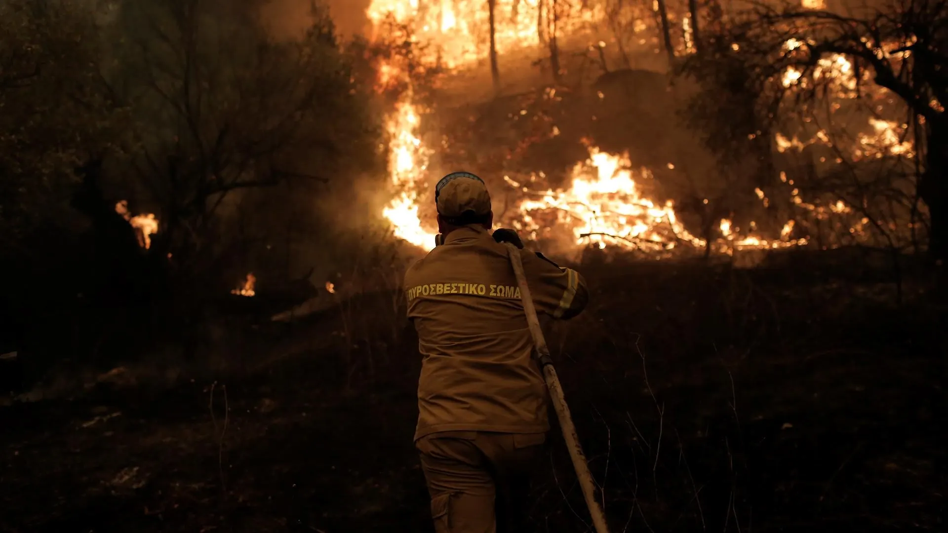 Un bombero combate las llamas durante un incendio en el pueblo de Pefki, Grecia