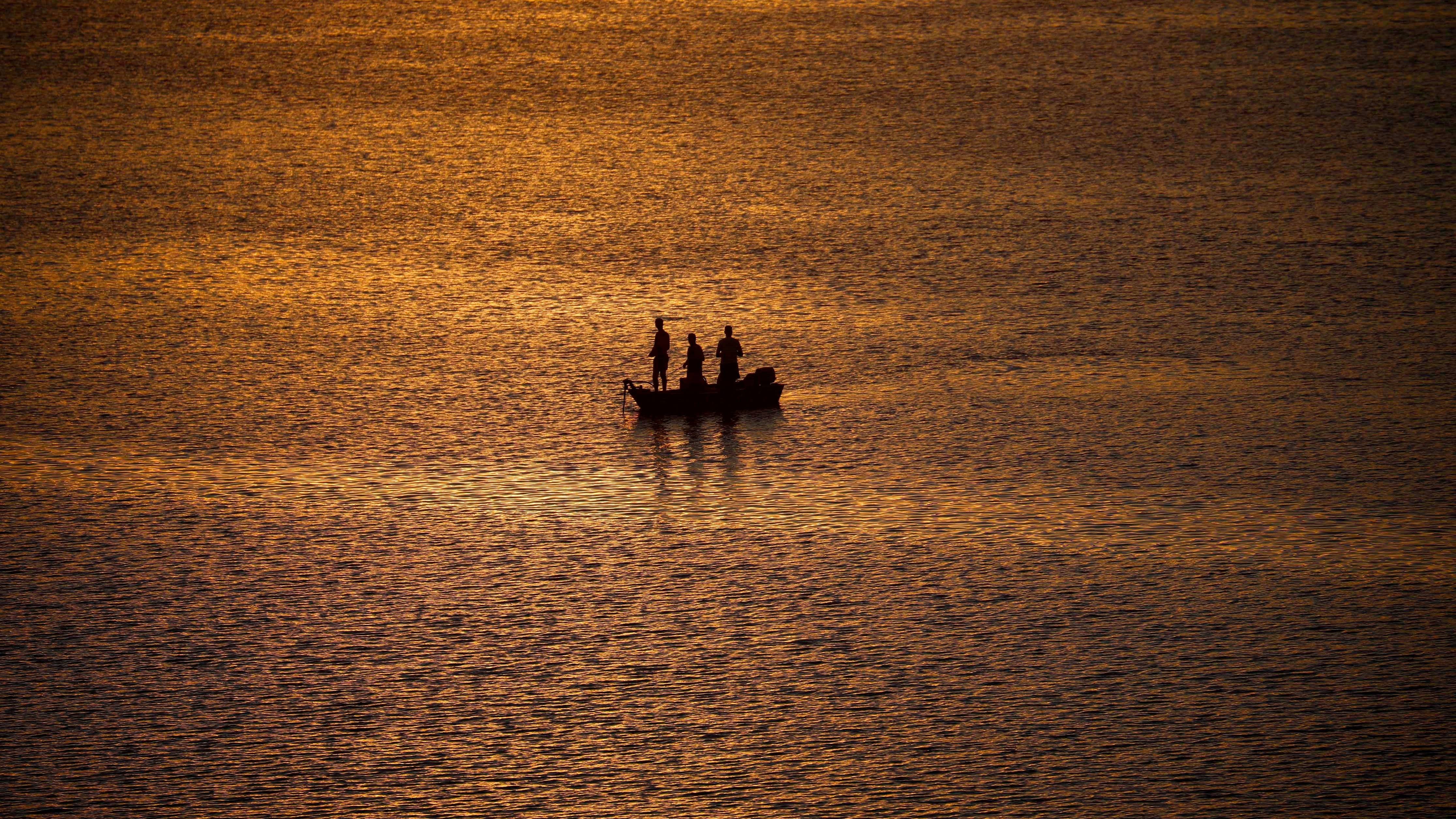 Unas personas pescando durante el atardecer en el pantano de la Breña, en Córdoba, en una jornada de temperaturas elevadas. 