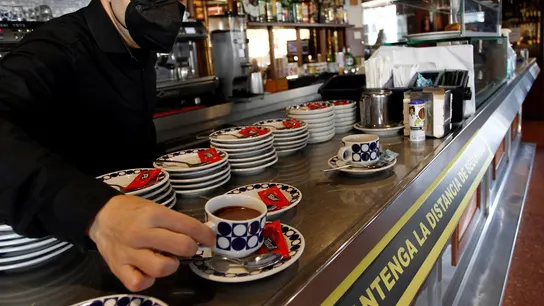 Un hostelero sirve un café en un bar de Galicia Un hostelero sirve un café en un bar de Galicia