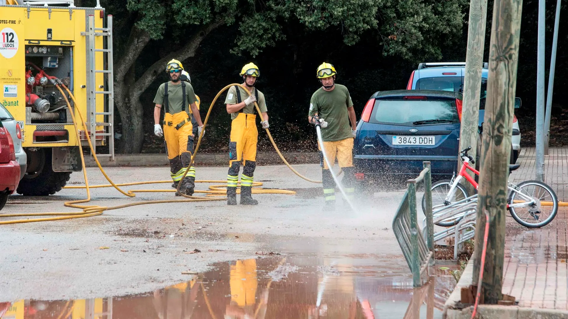 Miembros del IBANAT limpian las calles del fango acumuolado tras el desbordamiento del torrente. 