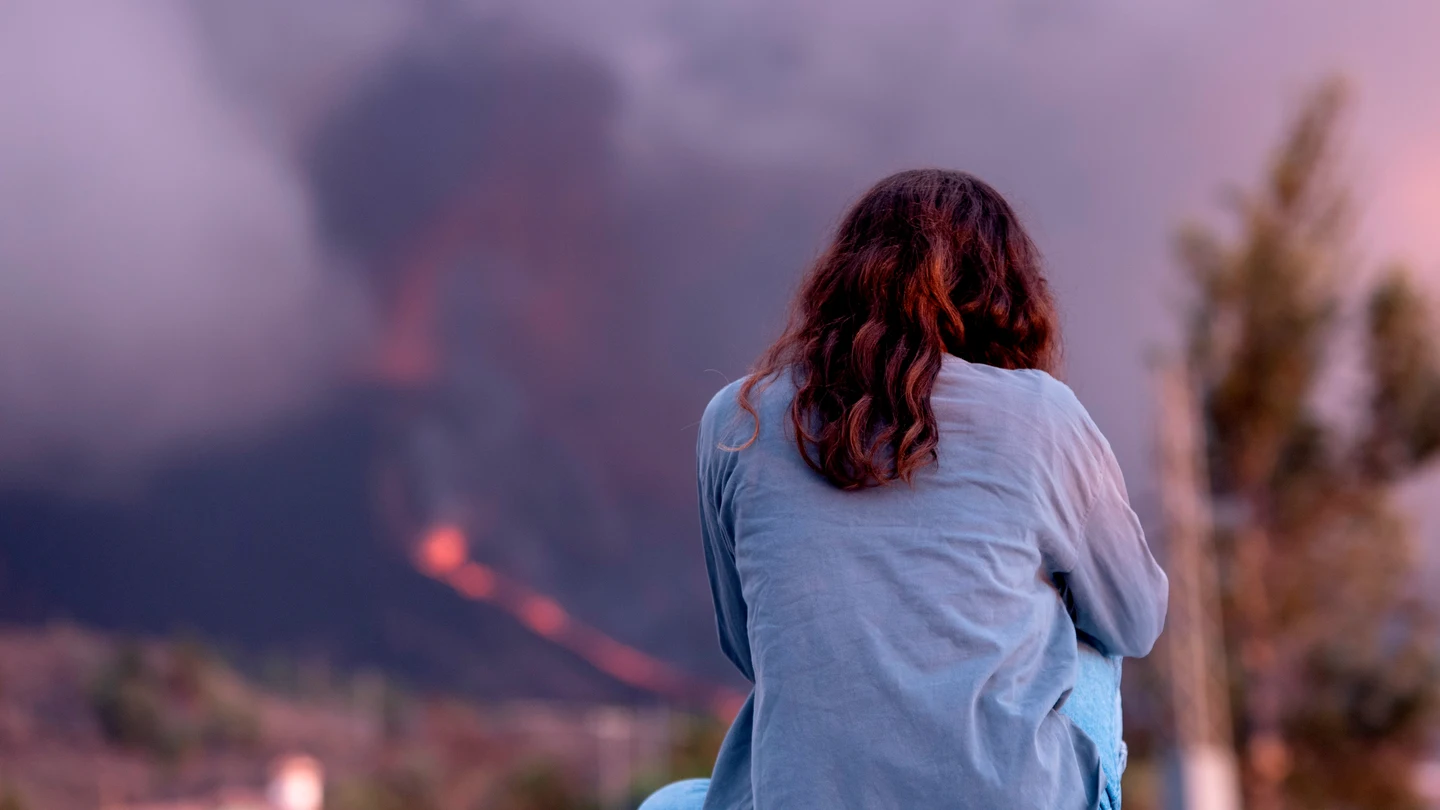 Una mujer observa el volcán de La Palma Una mujer observa el volcán de La Palma