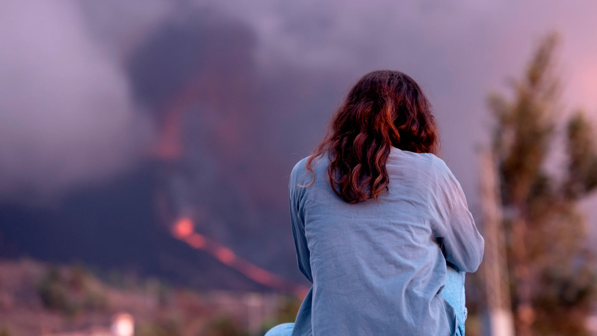 Una mujer observa el volcán de La Palma