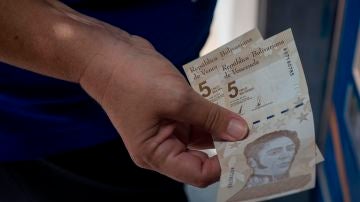 Personas retiran billetes del nuevo cono monetario en un cajero en Venezuela
