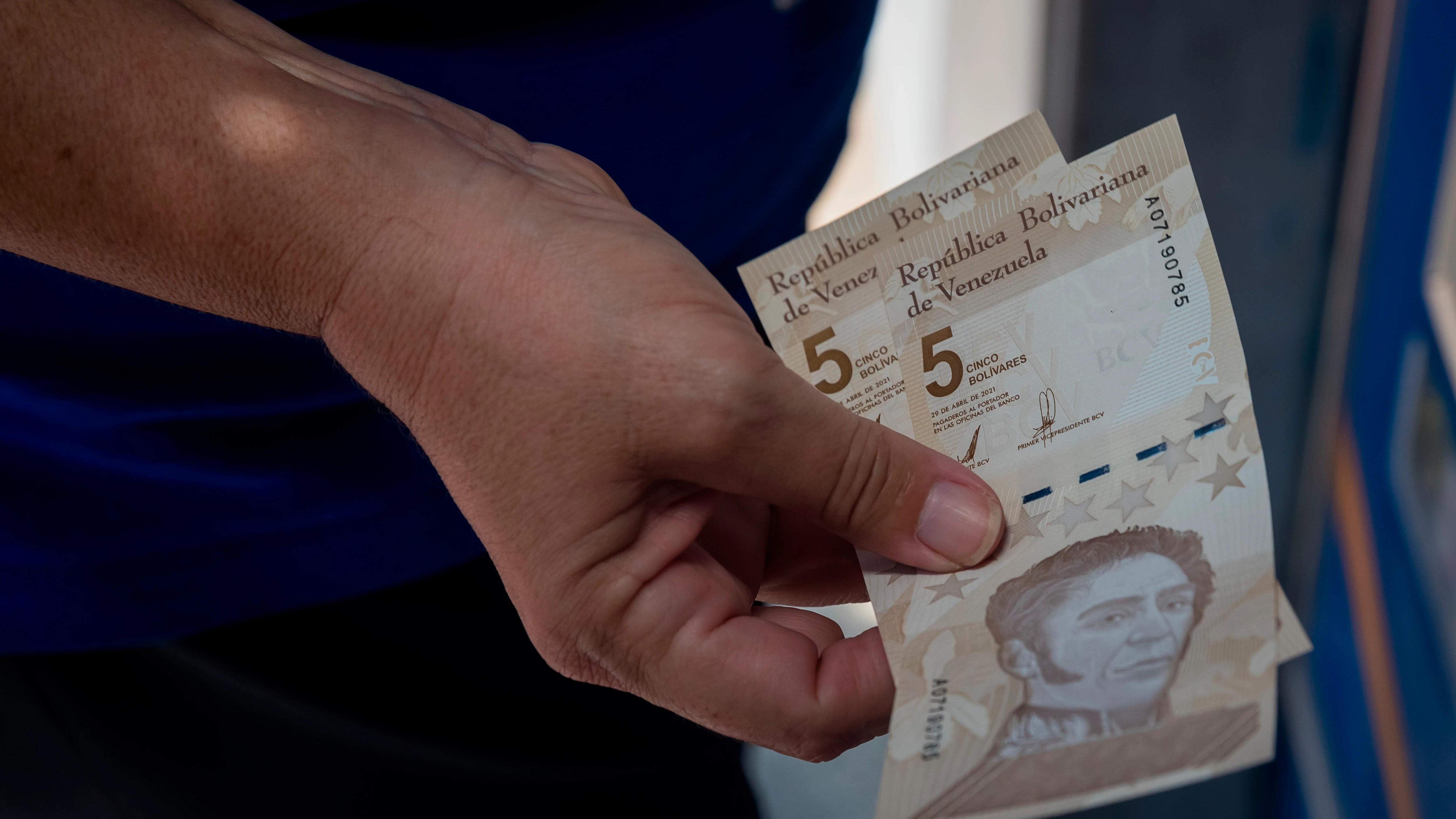 Personas retiran billetes del nuevo cono monetario en un cajero en Venezuela