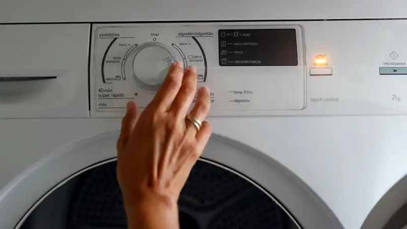 Una mujer poniendo una lavadora