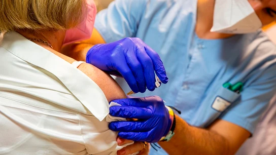 Una sanitaria inocula una vacuna a una mujer Una sanitaria inocula una vacuna a una mujer