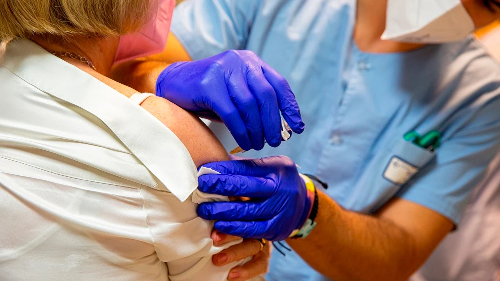 Una sanitaria inocula una vacuna a una mujer Una sanitaria inocula una vacuna a una mujer