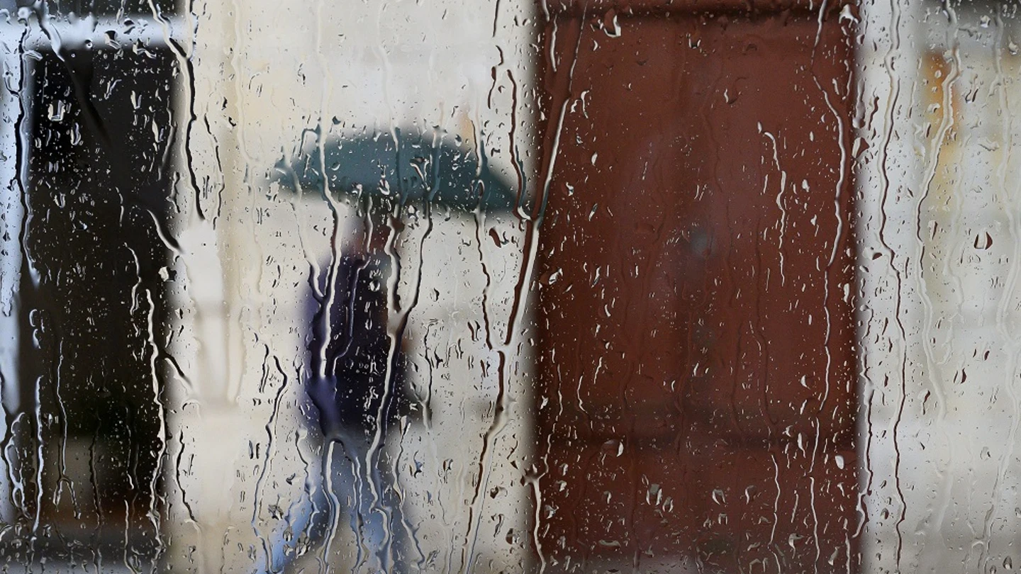 Un hombre camina bajo la lluvia en Santander Un hombre camina bajo la lluvia en Santander
