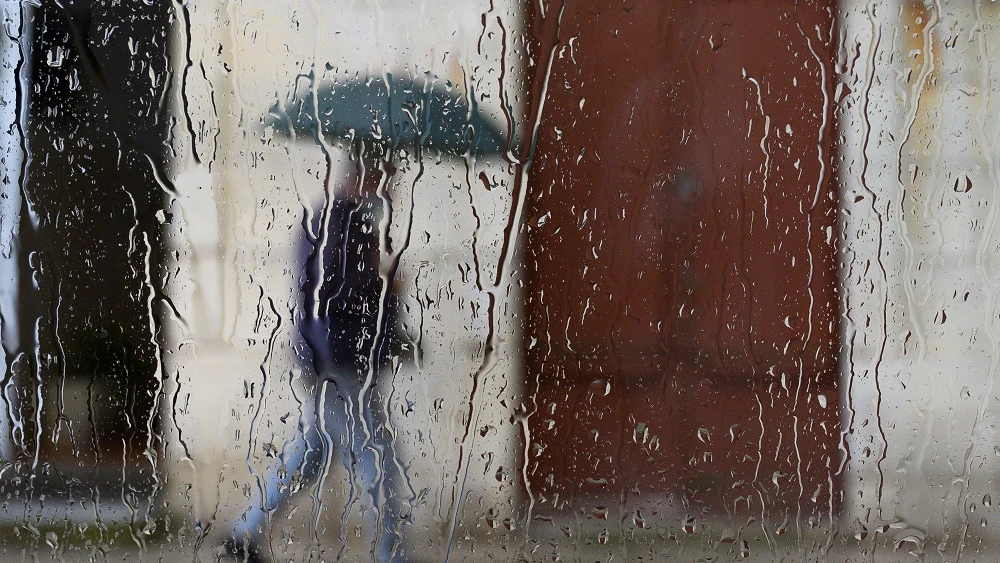 Un hombre camina bajo la lluvia en Santander