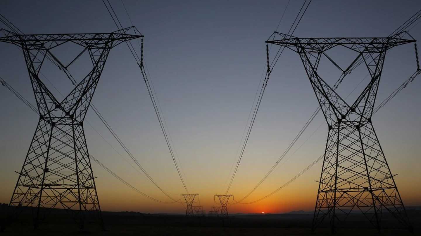 Amanecer tras unas torres eléctricas en una imagen de archivo Amanecer tras unas torres eléctricas en una imagen de archivo