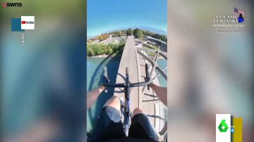 El impactante vídeo de un ciclista cruzando un río por el arco de un puente