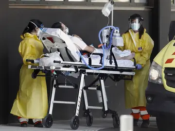 Dos sanitarias atienden a una persona a las puertas del hospital