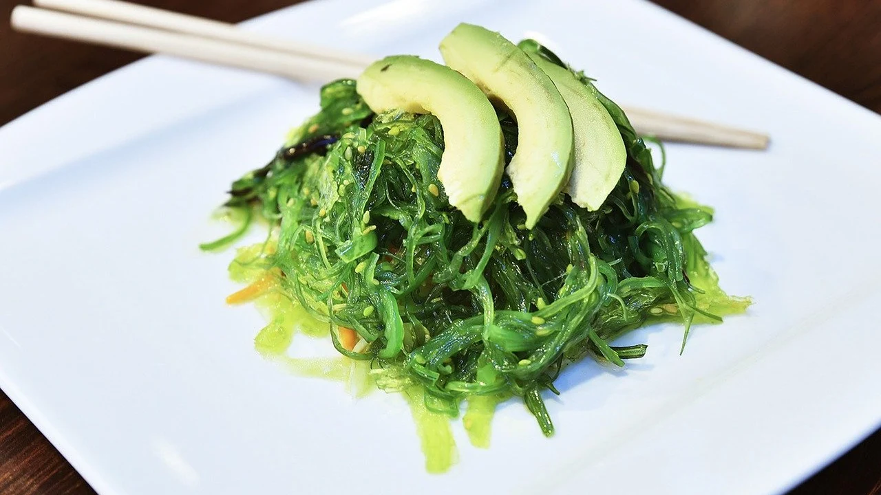 Imagen de archivo de un plato con alga wakame y rodajas de aguacate