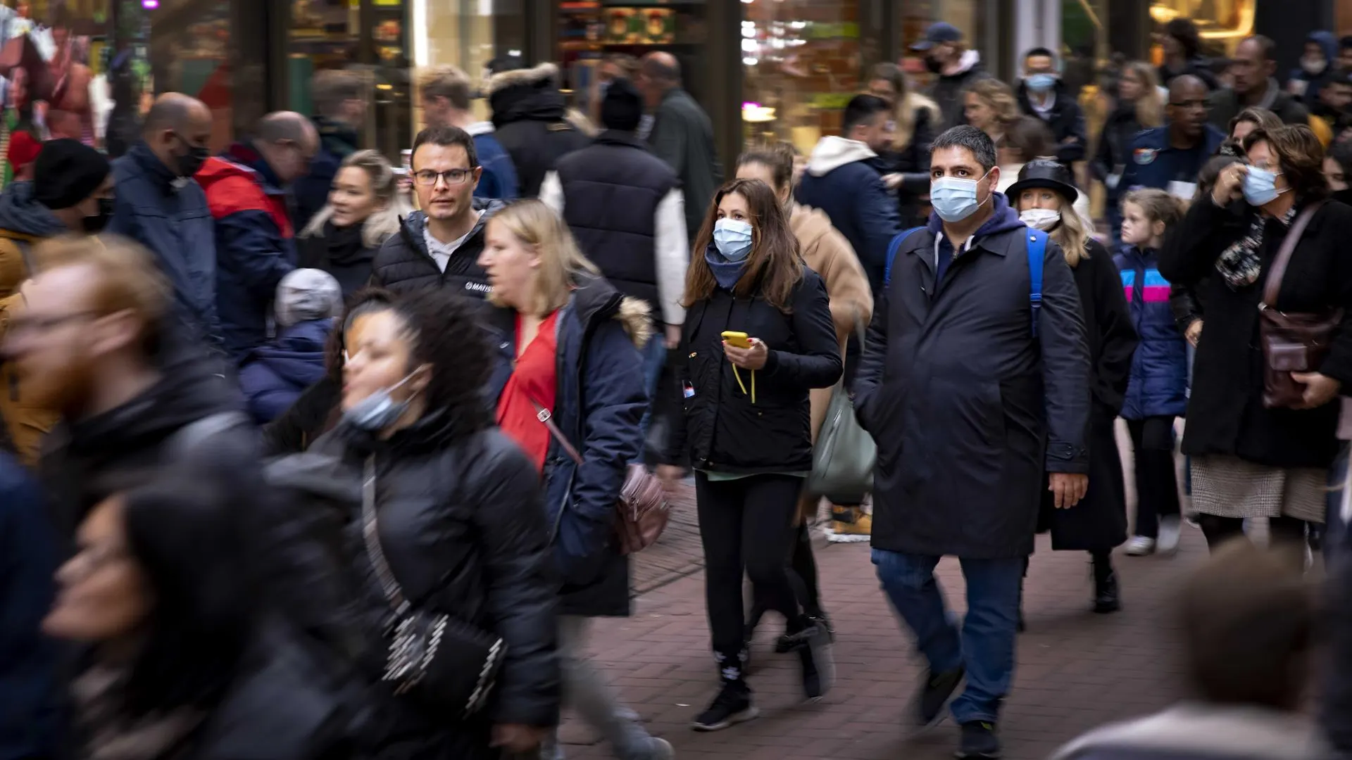 Varias personas en una calle céntrica de Ámsterdam llevando mascarillas por la pandemia de coronavirus