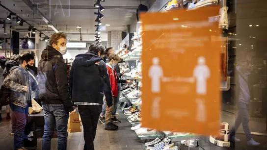 Varios clientes en una tienda con mascarilla por la pandemia de coronavirus Varios clientes en una tienda con mascarilla por la pandemia de coronavirus