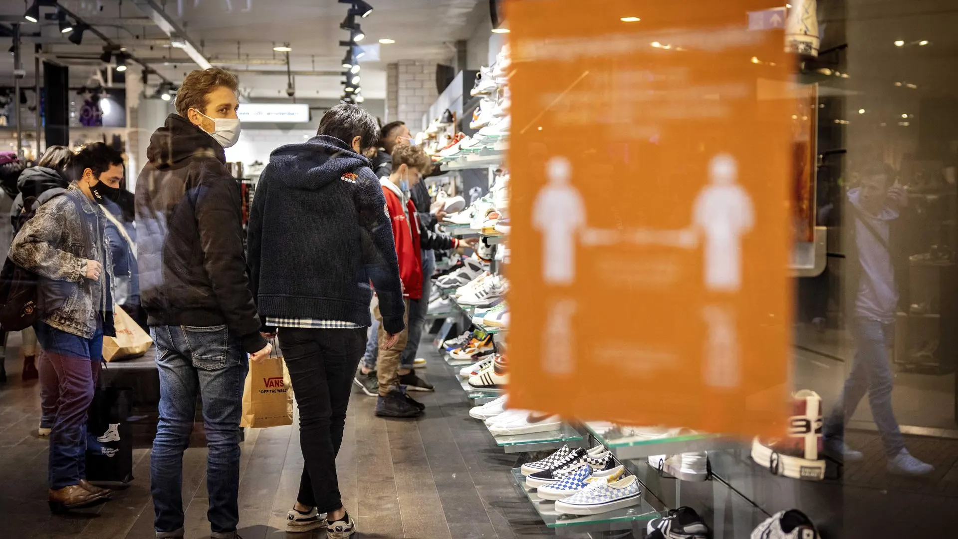 Varios clientes en una tienda con mascarilla por la pandemia de coronavirus