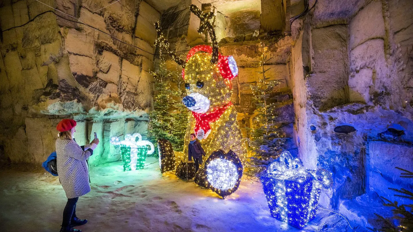 Una mujer camina entre la decoración de Navidad en el mercadillo de Valkenburg, Holanda Una mujer camina entre la decoración de Navidad en el mercadillo de Valkenburg, Holanda