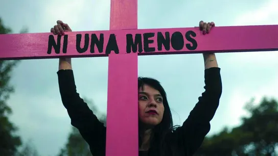 Una joven sujeta una cruz de color rosa durante una concentración contra la violencia machista Una joven sujeta una cruz de color rosa durante una concentración contra la violencia machista
