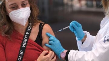 Una mujer recibe una dosis de la vacuna de Moderna durante la jornada especial de vacunación de refuerzo en Gigón (Asturias)