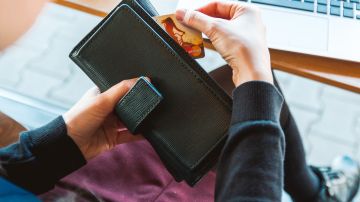 Una persona saca una tarjeta de crédito de su cartera