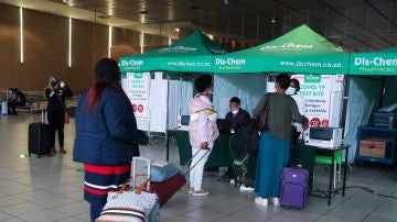 Varios pasajeros esperan para someterse a una PCR en el aeropuerto de Johannesburgo