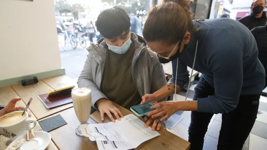 Un camarero comprueba el pasaporte COVID de un cliente en un bar del barrio de Gracia de Barcelona. Un camarero comprueba el pasaporte COVID de un cliente en un bar del barrio de Gracia de Barcelona.
