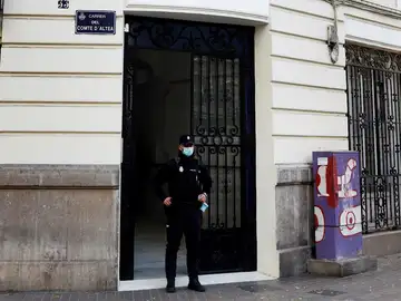 Un policía custodia el portal del edificio donde se halló el cuerpo de la víctima