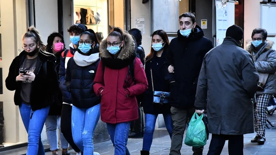 Varias personas pasean por la calle con mascarilla. Varias personas pasean por la calle con mascarilla.